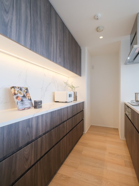 キッチンの背面にはお揃いのカップボードを備え付け、スタイリッシュな空間へと仕上げました。吊戸棚と収納が豊富にあり、キッチンのお料理グッズや保存食などをまとめて保存することができます。