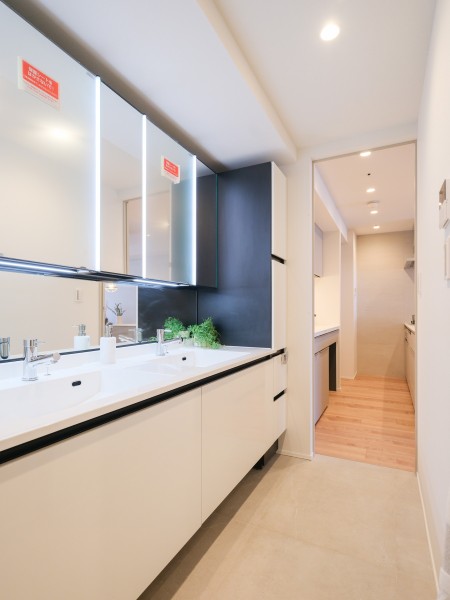 洗面室はホテルライクな2ボウル洗面化粧台と収納棚を設置いたしました。慌ただしいお出かけ前の準備時間も快適にお過ごしいただけます。ホテルで過ごしているような気持ちになれる空間です。