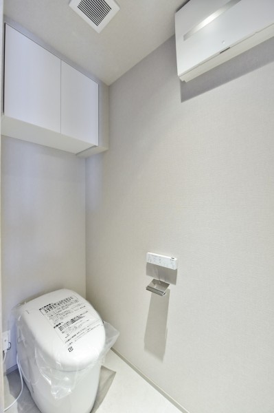 TOTO製ウォシュレット付タンクレストイレ新規交換しました。手洗いカウンターを設置し、ゲストも家族もいつも清潔に使用できます。吊戸棚がありますので、小物類を収納でき、すっきりとした空間を保てます。