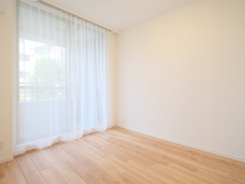 バルコニーから心地よい陽光が降り注ぐ洋室1はクローゼット付き、約5帖の明るいお部屋です。お部屋はどんなインテリアにも馴染みやすい、ナチュラルでシンプルな内装に仕上げています。