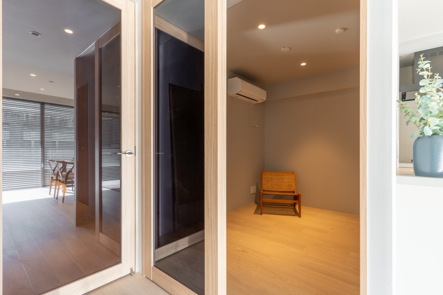 リビングと洋室3を仕切る扉は、スモーク調のガラス戸を採用しました。シームレスで閉塞感を感じない空間です。