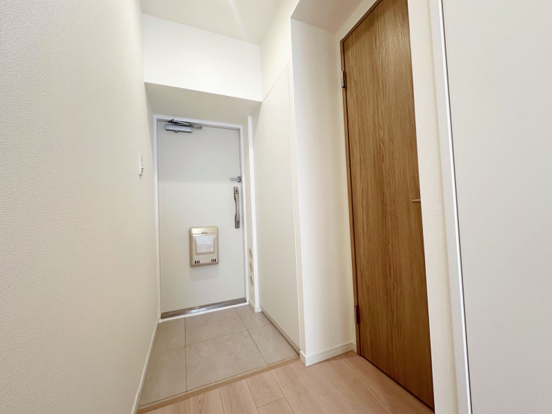 上品なホワイトと木の温もりを感じるナチュラルテイストの玄関スペースです。人感センサー付きライトを設置したので、暗い時間帯のご帰宅や両手が塞がっているときも快適です。