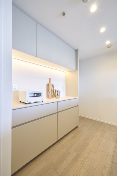 キッチンの背面にはお揃いのカップボードを設置しました。収納豊富でカウンタースペースも広く、実用的です。カウンター部分にはワインやオシャレな家電を置いて、インテリアとしても楽しめそうです。