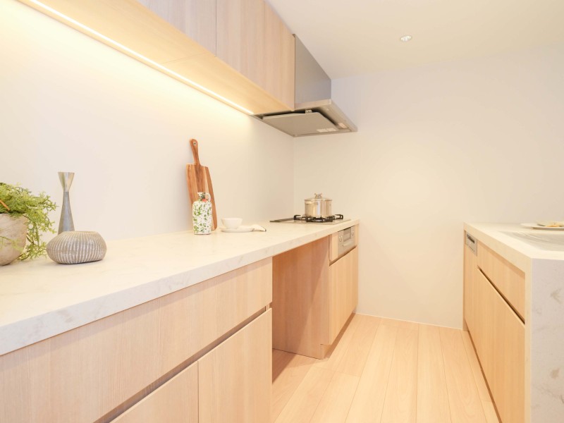 美しい木目の面材と石調の天板が、インテリアの一部のようでお部屋の雰囲気に溶け込みます。作業スペースにゆとりあるⅡ列型キッチンです。