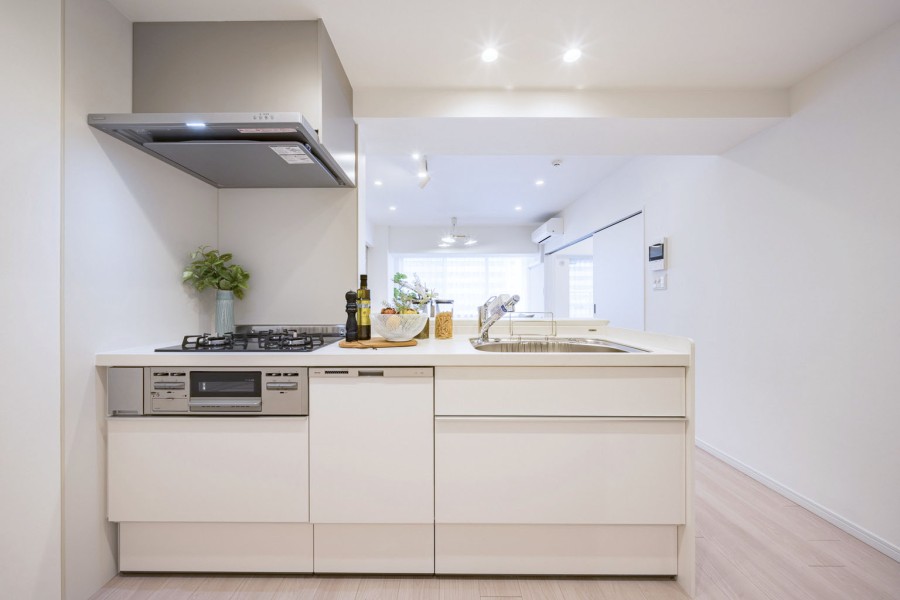 お部屋の雰囲気に溶け込む清潔感が漂うホワイトカラーのキッチンを新規交換しました。開放的なオープンタイプながらも、コンロ前は仕切りがあるので油ハネ等のお手入れもしやすいです。