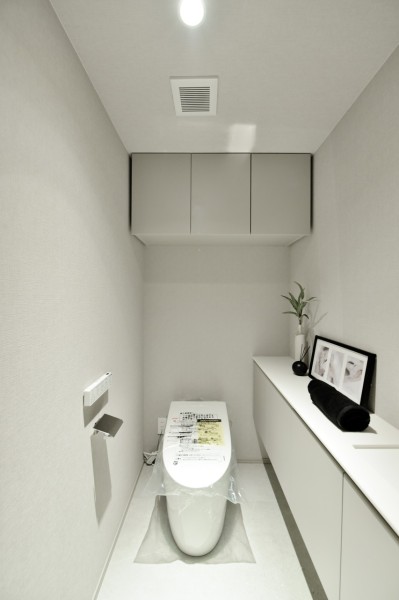 TOTO製ウォシュレット一体型のタンクレストイレを新規設置しました。毎日使用する場所だからこそ、ホワイトで統一したシンプルで清潔感ある空間に仕上げました。吊戸棚設置済みで、小物類の収納に便利です。