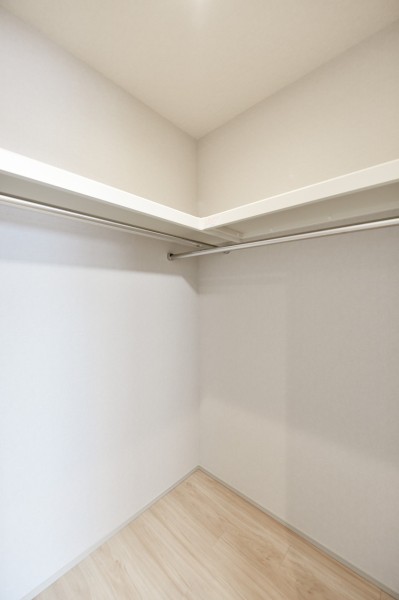 洋室１にはハンガーパイプに枕棚を備え付けたウォークインクローゼットを設置しました。かさばりがちなアウターや、小物類、シーズンオフの家電など使用頻度の低いアイテムもたっぷり収納できます。