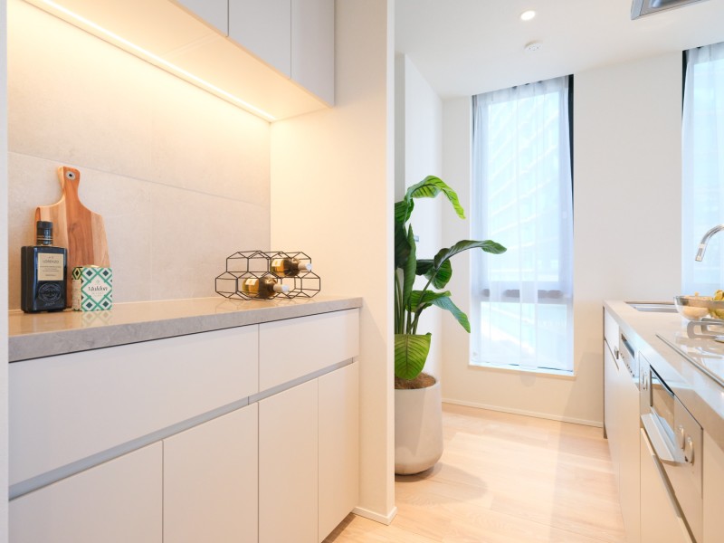 キッチン背面にカップボードを備え付けた、食器や調味料がスマートに収まる設計です。棚下灯の光がアクセントとなり、日々使う調理家電やこだわりの雑貨をより魅力的に演出します。