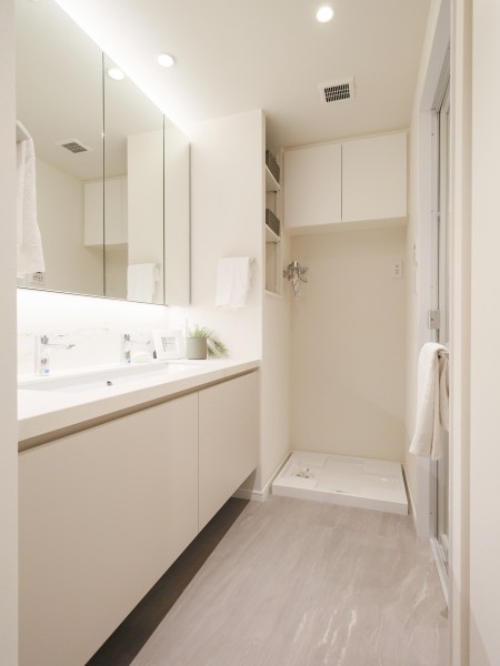 ゆとりのある田中工藝製洗面化粧台は大きな鏡が印象的なラグジュアリーな空間です。また、置場に困るタオルや着替え、ストック用品などを収納できるリネン棚を造作しました。