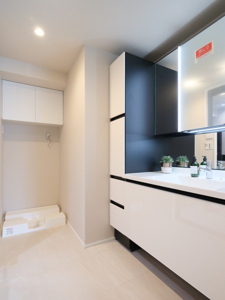 白を基調とした、清潔感溢れるスタイリッシュなデザインの洗面化粧台。リネン類などの収納に便利な棚を備え付けました。