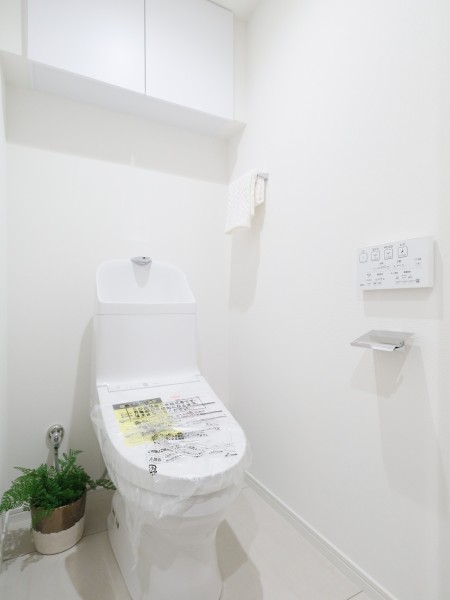 シンプルで安らぎが宿るレストルームです。ウォシュレット一体型のトイレは、お掃除の手助けをしてくれる便利機能が搭載されています。トイレットペーパーなどの収納に便利な吊戸棚を備え付けました。