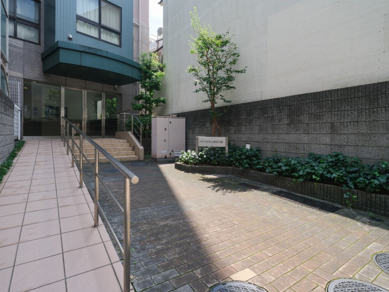 植栽の緑が心地よさを感じさせるエントランスです。建物へと続くアプローチに彩りを添え、住まう方や訪れる方をやさしく迎えます。