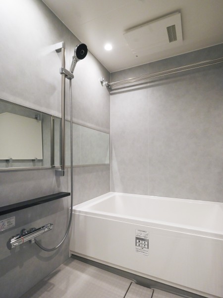 凹凸を抑えたすっきりとしたデザインのトイレです。操作パネルを壁面に設置し、落ち着いた色合いの内装が空間を引き締めています。
