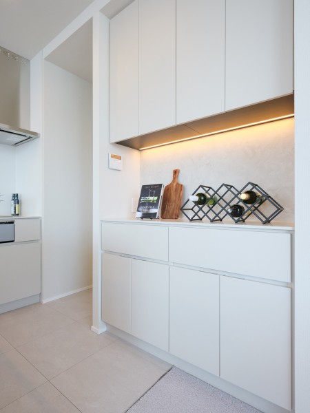 キッチン背面にはカップボードを造作しました。間接照明が照らし、調理家電や食器などをおしゃれにディスプレイできます。食品、調味料なども収納できる便利スペースです。