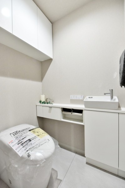 タンクレストイレですっきりとした空間になっております。手洗いカウンター付で、家族やゲストがいつも清潔に使用できます。吊戸棚があり、小物類の収納にも便利です。