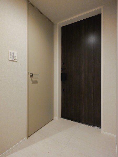 ゆったりとスペースのひらけた玄関前です。大きな荷物があっても出入りがしやすく、ショッピング時も安心して楽しむことができます。落ち着いたカラーの壁紙とフロアー材にすることで、気品のある玄関となっています。