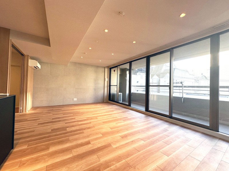 L字型のバルコニーに囲まれた明るく開放的なLDKです。南東角住戸、ハイサッシから優し光が差し込み、爽やかな風が心地よい、快適な空間です。壁にはタイルを貼り、ナチュラルながらもエレガントな空間に仕上げました。