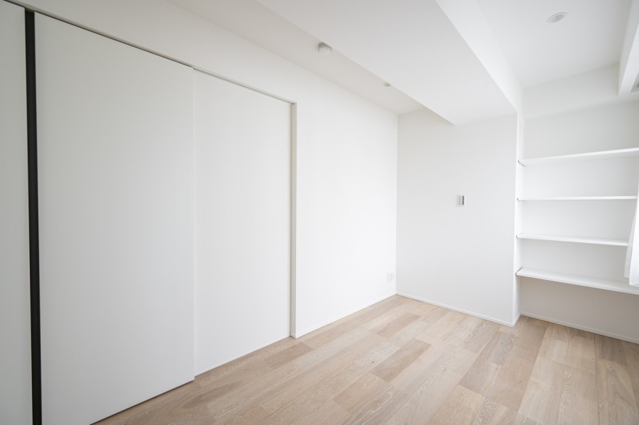 洋室2は約5.6帖の広さがあり、主寝室としてお使いいただけます。凹凸が少ないシンプルな内装のため家具が配置しやすいようになっております。収納棚を設置しているためインテリアや小物など見せる収納をすることができます。