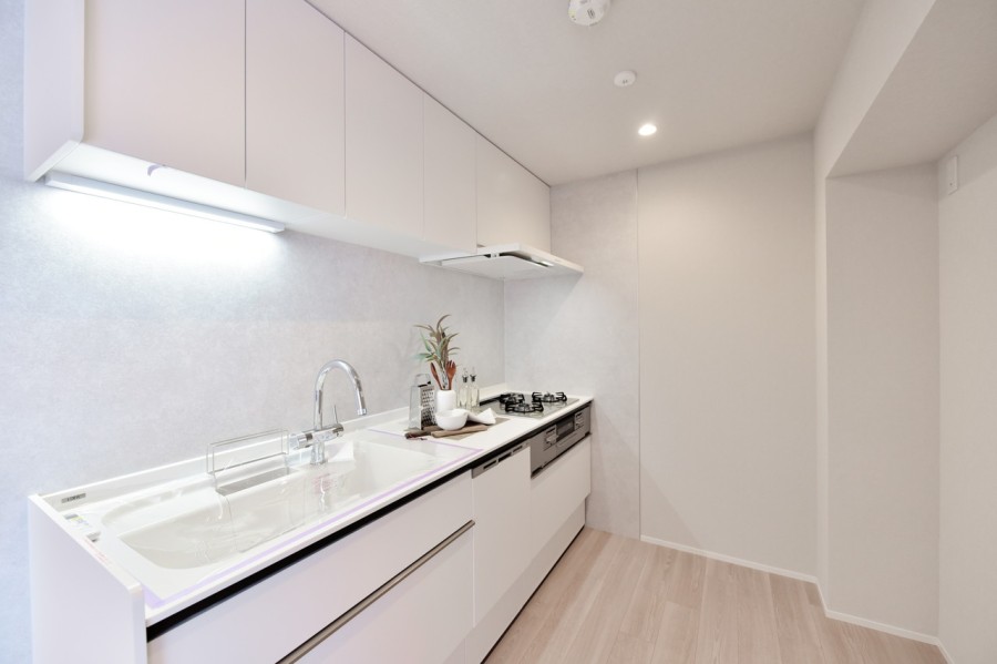 ホワイトの清潔感あふれるシステムキッチンです。食器洗い乾燥機完備で、家事の時短に役立ちます。吊戸棚を設置していますので、調理器具や調理家電をたっぷりと収納でるので、スペースを有効活用できます。