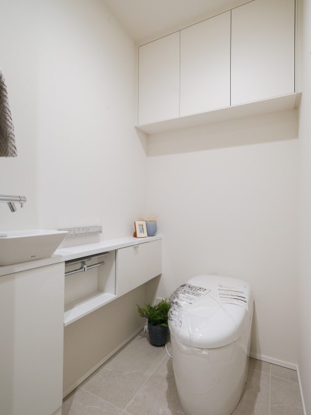 清潔感が溢れるレストルームにはタンクレストイレと吊戸棚と手洗い場があります。毎日使う場所だからこそ、スタイリッシュで機能的な空間を演出しました。