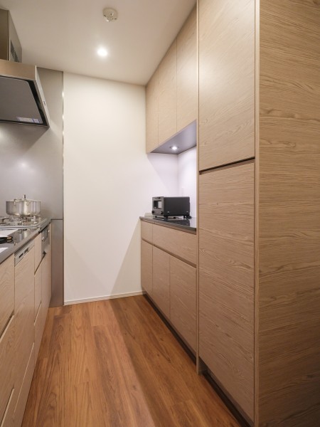 キッチンの背面にはお揃いのカップボードが設置されております。収納がたくさんあり、食器や調味料などまとめて収納できます。カウンター部分には調理家電やワインなどを置けるようになっております。