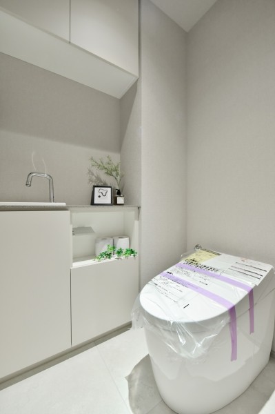 TOTO製ウォシュレット一体型タンクレストイレ新規交換済みです。キッチンと同じく田中工藝社製の手洗いカウンターを設置済みです。上部には吊戸棚を設置し、小物類などもきれいに整頓できます。