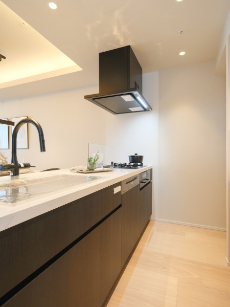 モノトーンカラーで整えられたキッチンは田中工藝製のオリジナルシステムキッチンです。優しい色合いの内装のアクセントとなっており、大人モダンなキッチンスペースを演出します。