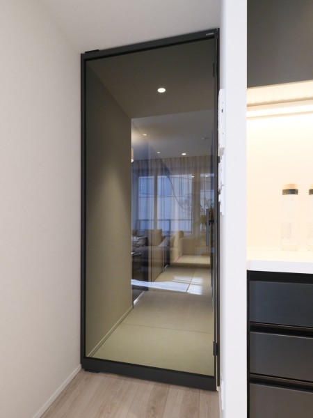 リビングへ続く扉はガラス仕様で、空間に開放感と軽やかさを演出します。周囲の素材と調和する仕上げで、住まい全体に落ち着いた雰囲気を添えています。
