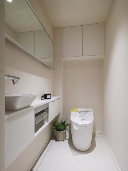 タンクレストイレやスティックリモコンで、スタイリッシュな雰囲気を演出したレストルームです。収納棚や手洗い水栓があり、使い勝手にまでこだわった機能性の高い空間です。