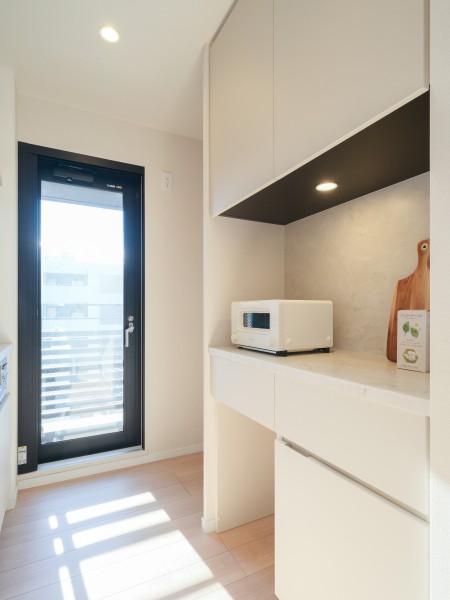 背面にはキッチンとお揃いのデザインのカップボードを備え付けました。キッチンはサービスバルコニーに繋がるので換気ができるスマートな空間です。南西向きの窓から自然光が降り注ぐ、安らぎのスペースです。