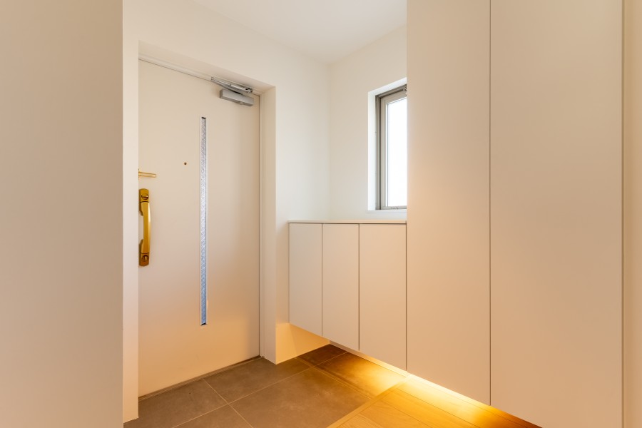 窓がつくる開放感と、灯りがつくる安心感で包まれる玄関です。フットライトの照明が足元をドラマチックに演出します。