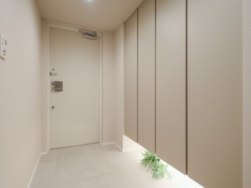 住まいの顔になる玄関は、フットライトが足元を温かく照らし、爽やかな空間を演出します。天井までの高さがあるシューズボックスを備え付けたので、玄関をすっきり綺麗に保てます。