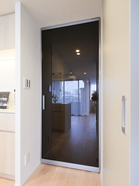 リビングへ続く扉はガラス仕様で、空間に開放感と軽やかさを演出します。周囲の素材と調和する仕上げで、住まい全体に落ち着いた雰囲気を添えています