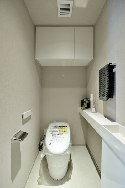 TOTO製ウォシュレット一体型のタンクレストイレ新規交換済みです。手洗いカウンターを設置していますので、家族やゲストがいつも清潔に使用できます。吊戸棚設置済みで、小物類の収納に便利です。