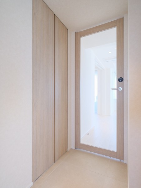 リビングへと続く扉には、透明感あふれるガラス戸を採用しました。視線の抜けを作ることで、廊下まで自然光が届く開放的な住まいです。木の温もりとガラスの質感が調和し、空間全体をスタイリッシュに引き締めます。