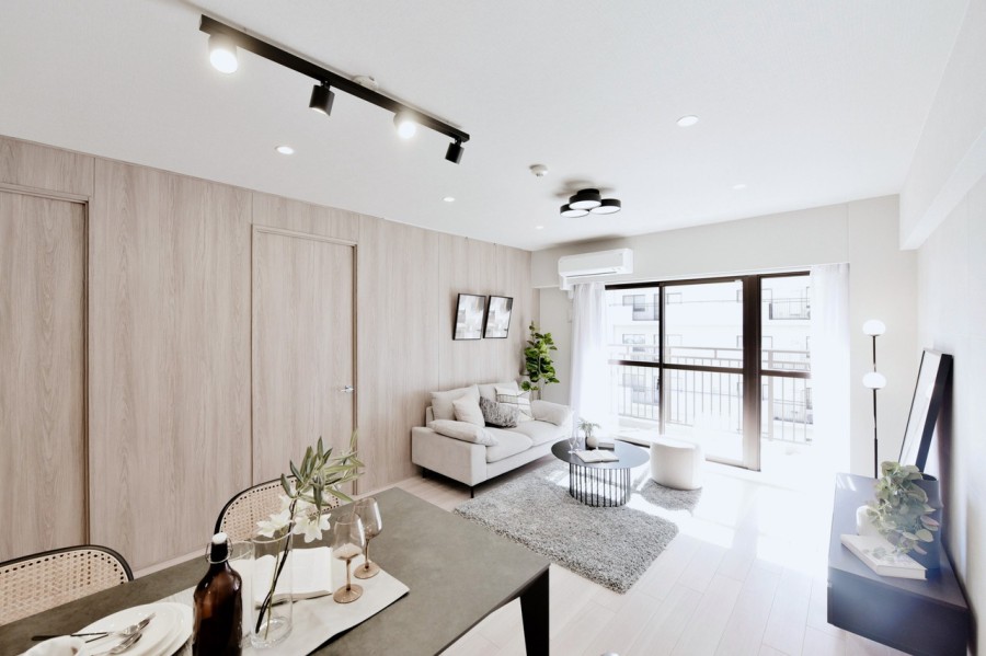 リビングの壁には木目調の化粧パネル、主張しすぎない天然石風の質感が美しいタイルを貼り、高級感のある内装に仕上げました。壁にはピクチャーレールを設置しており、アートやグリーンでお好みの空間を演出できます。