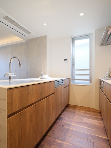 シンク側を対面、コンロ側を壁付に配したペニンシュラ型のキッチンを採用しました。キッチン横には光を取り込むライトウェルがあるので、開放的で通風も良好な空間です。