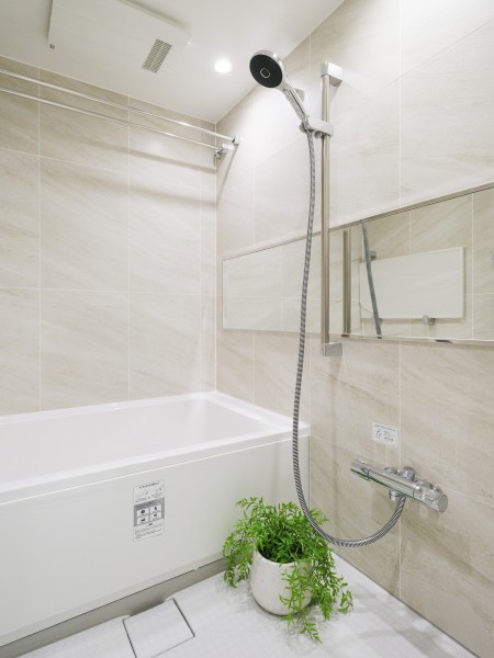 明るい色調のタイルがやさしい雰囲気をつくり出すバスルームです。横長ミラーの効果により空間に広がりが感じられます。すっきりとしたデザインで、毎日のバスタイムを快適に過ごせます。