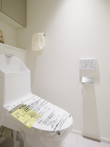 白を基調とした明るいレストルームで、すっきりとした内装が清潔感のある空間をつくり出しています。上部には収納が設けられ、日用品もすっきり片づけられる使いやすい仕様です。