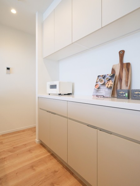 背面にはカウンタースペースにゆとりがある、同デザインのキッチン収納を備え付けています。カトラリーやキッチンツールはもちろん、ストック類などもたっぷり収納いただけます。