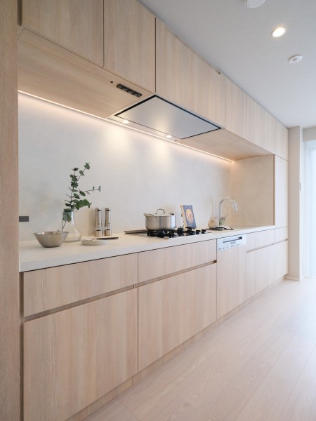 レンジフードまで納めたフラット設計のオリジナルキッチン。美しい木目の面材はインテリアの一部のようでお部屋の雰囲気に溶け込みます。