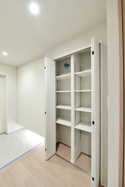 玄関横の廊下部分にも収納を設置しました。お出かけの際にサッと取り出したいレイングッズや、家族共用のもの、災害備蓄品などの収納に役立ちます。