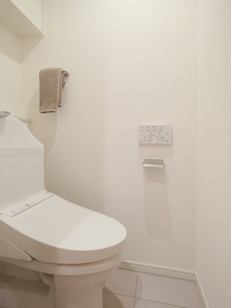 シンプルで安らぎが宿るレストルームです。吊戸棚にはトイレットペーパーや掃除用具を収納でき、生活感を抑えたすっきりとした空間を実現します。