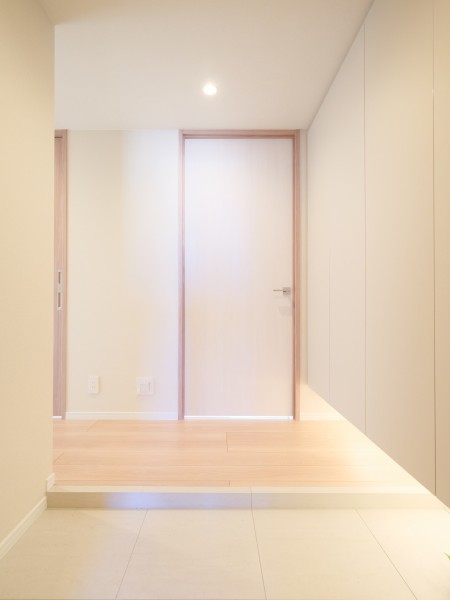 足元を照らす間接照明が上質な雰囲気を演出する玄関です。新規交換した大型のシューズボックスを備えており、ご家族全員の靴類を整然と収納できます。すっきりとした空間で気持ちよくお客様を迎えられます。