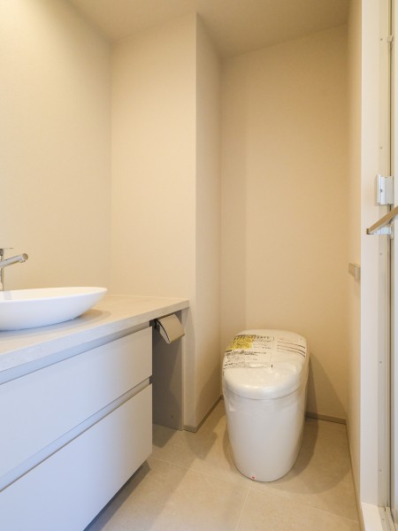 手洗いカウンター付きのトイレ空間です。すっきりとしたデザインで清潔感があり、ゆとりを感じられる落ち着いた設えです。