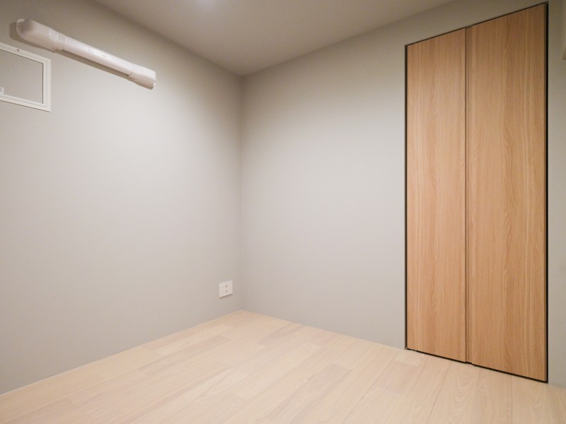 木目調の収納扉を備えたサービスルーム(納戸)です。シンプルな色味と素材を採用し、幅広いインテリアと調和する内装に仕上げました。